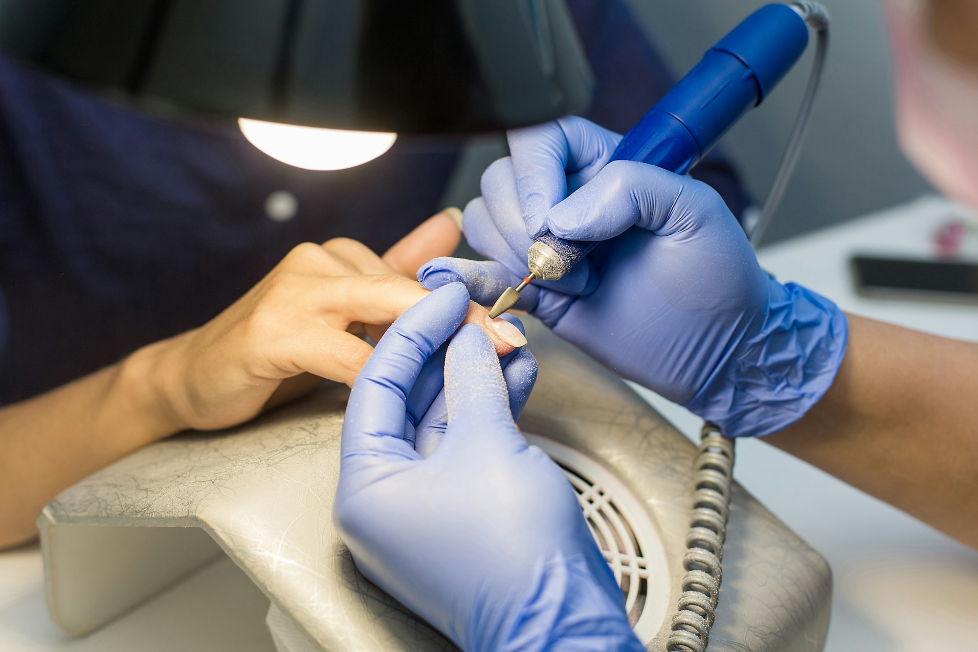Nails Manicure. The manicurist will remove the coating with the apparatus. Hardware manicure.