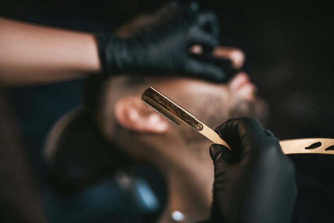 Close up of man shaving in retro barbershop